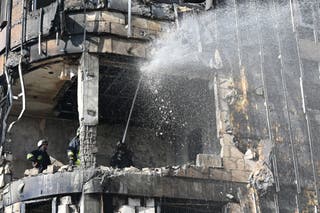 Ukrainian rescuers work to extinguish a fire in a damaged residential building following a drone attack in Kharkiv on 2 April 2026, amid the Russian invasion of Ukraine